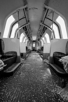 Symmetrical black and white interior of an abandoned train or subway car with arched ceiling