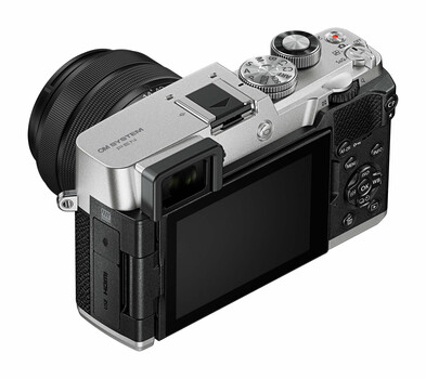 Silver and black mirrorless camera with articulating LCD screen and compact prime lens attached
