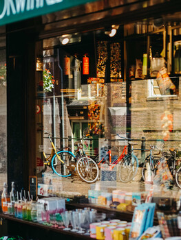 Storefront window display featuring bicycles and merchandise under warm golden lighting