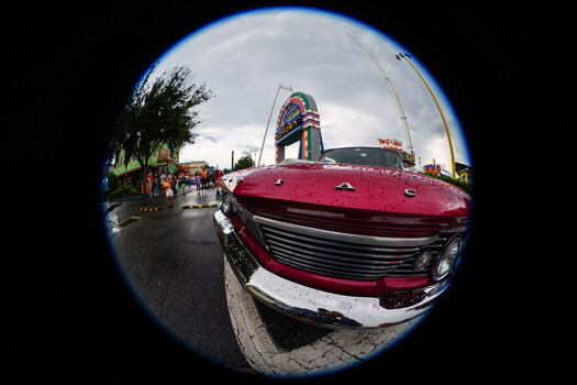 Vintage pink and white car with chrome grille captured with fisheye lens distortion