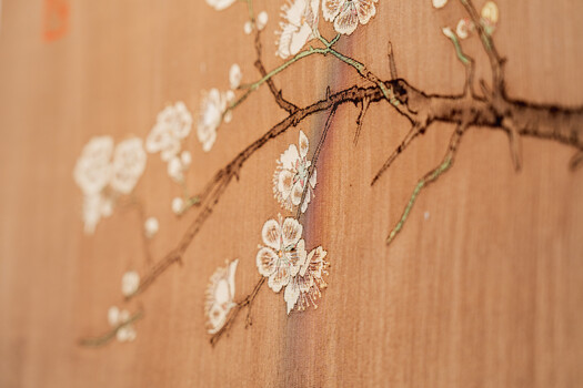 Delicate white lace flowers hanging from bare branches against warm wooden background