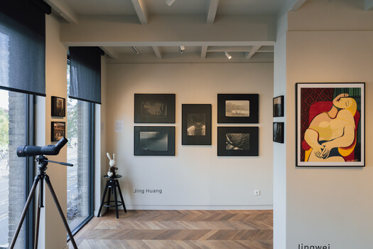 Contemporary art gallery interior with framed artworks on white walls and a colorful abstract painting