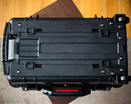 Bottom view of black camera battery grip with battery compartment doors and mounting hardware