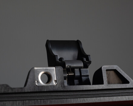 Close-up of firearm iron sights and rear aperture assembly mounted on rifle receiver
