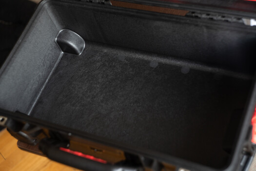 Interior of a black camera equipment case or storage box with protective padding