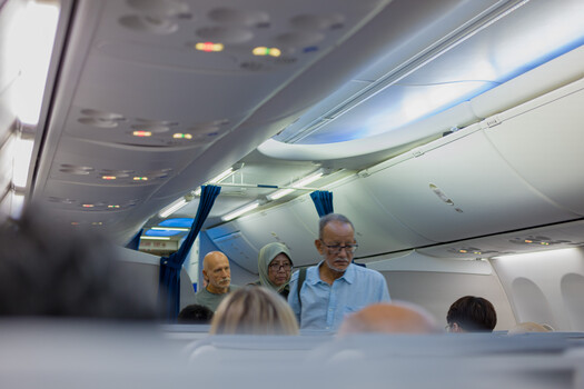 Flight attendants demonstrating safety procedures in airplane cabin aisle