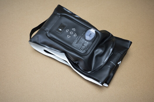 Camera flash unit with battery compartment open, showing interior mechanisms and battery contacts