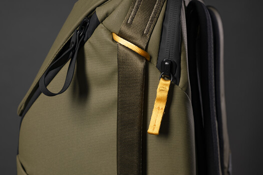 Olive-green travel backpack with yellow accent straps and black trim detail