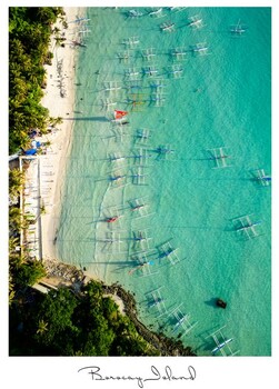 Aerial view of turquoise shallow water with scattered boats anchored near a sandy beach and tree-lined shore