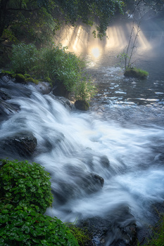 A waterfall bathed in rays of light by yuusei nagahata