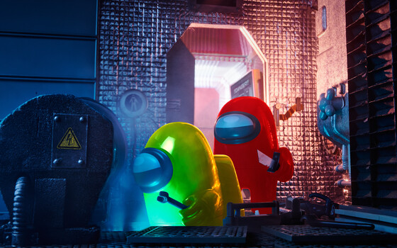 Colorful 3D printed figurines illuminated with neon lighting in an industrial setting
