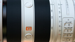 Close-up of a telephoto lens showing focus ring, aperture markings, and autofocus switches.
