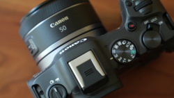 Canon EOS R5 mirrorless camera with Canon RF 50mm lens mounted, shown from above on wooden surface.