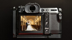 Mirrorless camera displaying a wedding ceremony photograph on its rear LCD screen.