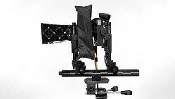 Overhead view of a camera rig with articulating arms, mounting plate, and control handle on white background.