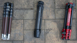 Three tripods displayed on concrete ground showing different designs and colors.