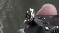 Close-up of a camera's hot shoe mount and grip detail against blurred background.