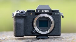 Fujifilm X-S20 mirrorless camera body with lens mount exposed against blurred yellow-green background.