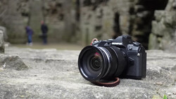 Olympus camera with attached lens resting on weathered concrete surface.