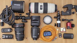Professional photography lighting and lens equipment arranged on a wooden surface.