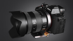 Sony mirrorless camera with wide-angle lens and lens hood mounted on gray background.