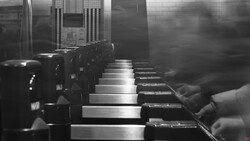 Black and white photograph of a row of identical mechanical devices or machinery components lined up in perspective.