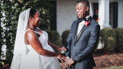 Bride and groom exchange rings during outdoor wedding ceremony.
