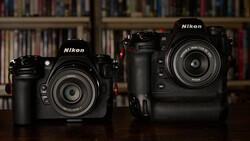 Two black Nikon DSLR cameras displayed side by side on a wooden surface.