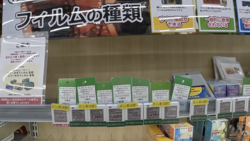 Retail shelf displaying film stock products with green and white packaging boxes arranged in rows.