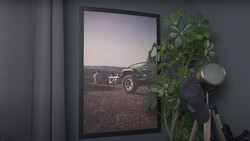 Framed photograph of a vintage truck and figure in an arid landscape displayed on a gallery wall.