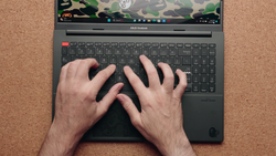 Overhead view of hands typing on an ASUS Vivobook laptop with camouflage pattern on screen.