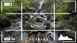 Camera viewfinder overlay displaying cascading waterfall with mossy rocks and long-exposure water effect.