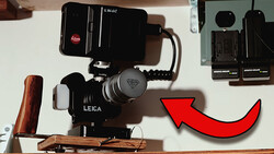 Leica rangefinder camera mounted on a wooden baseplate with a video light and external recorder setup.
