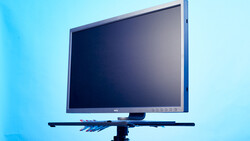 Professional monitor mounted on articulating arm against blue background.
