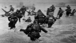 Soldiers wading through ocean water during an amphibious landing operation.