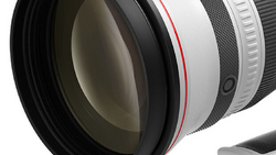 Close-up cross-section of a camera lens showing internal glass elements and mechanical components.