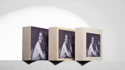 Three wooden display boxes arranged in a row, each featuring the same black and white portrait photograph of a woman.