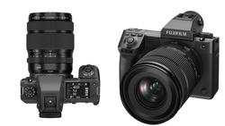 Two mirrorless cameras displayed from above: a compact model with telephoto lens on the left, and a larger body with wide-angle lens on the right.