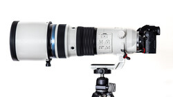 Large telephoto lens mounted on a ball head tripod with camera body attached on the right side.