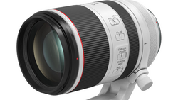 White and black telephoto lens with red accent ring and manual focus controls.
