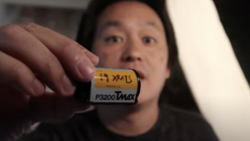 Person holding a vintage film cartridge labeled P3200 Tmax against blurred background.