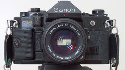 Canon F-1 35mm SLR camera with Canon FD 50mm f/1.4 lens mounted, shown from front against white background.