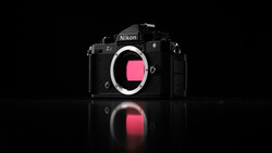 Nikon Z7 mirrorless camera body shown front-on against black background with mirror reflection below.