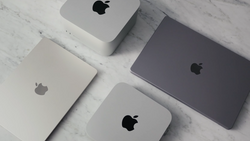 Four Apple devices arranged on white marble surface in flat lay composition.