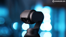 Three-axis gimbal stabilizer with mounted camera against blurred blue bokeh background.