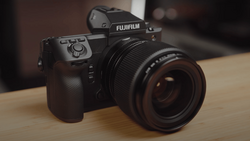 Fujifilm GFX medium format camera with attached lens on wooden surface.