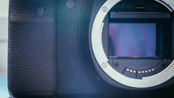 Camera body with open mirror box revealing sensor and internal mechanics.