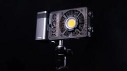 Professional LED light fixture mounted on a studio stand against a black background.