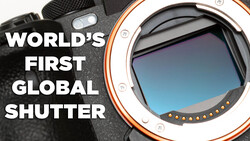 Close-up of a camera body with orange and white accent ring showing the mirror and sensor. Text reads 'World's First Global Shutter.'
