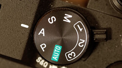 Close-up of a camera mode dial showing P, A, S, M, and AUTO settings with the dial positioned on AUTO.